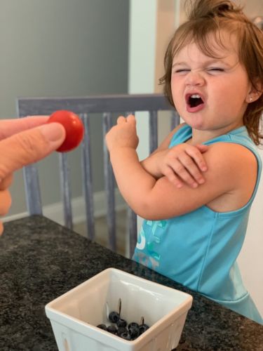 Girl refusing tomato